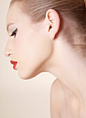 Close up profile of beautiful young woman with red lipstick\n