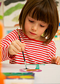 Portrait eines jungen Mädchens beim Malen mit Aquarellfarben