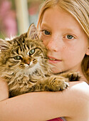 Close up of young girl hugging kitten\n