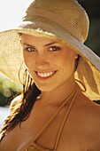 Portrait of young woman with straw hat\n
