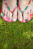 Close up woman feet wearing flip flops\n