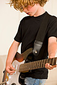 Young boy playing electric guitar\n