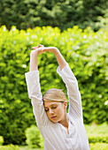 Young woman with arms stretched and eyes closed\n