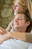 Close up of a young couple hugging and smiling\n