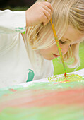 Close up of a young blonde girl painting\n