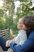 Profil eines jungen Paares sitzend und sich umarmend