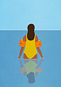 Frau in Badeanzug und Schwimmflügeln watet im Meerwasser