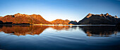 Herbstsonnenaufgang über den Bergen und dem Küstendorf Sildpollnes, Austnesfjorden, Svolvaer, Lofoten, Nordland, Norwegen, Skandinavien, Europa