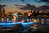 Paddle Boarding bei Nacht am Miami Beach, Miami, Florida, Vereinigte Staaten von Amerika, Nordamerika