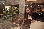 Woman shopping for cushions in store\n