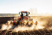 Traktor pflügt Feld an einem sonnigen Tag