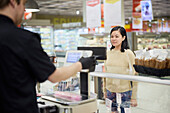 Female customer in supermarket buying products at deli counter\n
