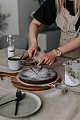 Woman cutting freshly baked chocolate cake\n