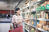 Young woman shopping during inflation in supermarket\n