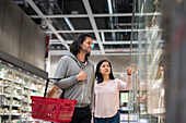 Young couple shopping during inflation in supermarket\n