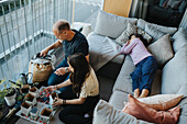 Father and daughters bonding over planting seedlings on balcony\n