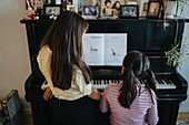 Schwestern beim gemeinsamen Klavierspielen