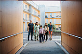 Portrait of family standing in courtyard of residential neighborhood\n