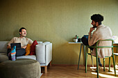 Homosexual couple relaxing in living room\n