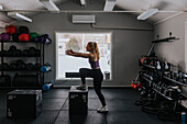 Side view of young woman training in gym\n