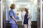 Female doctors taking to each other inside lift in hospital\n