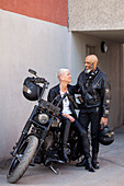 Cooles reifes Biker-Paar in Lederklamotten posiert mit Motorrad