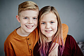 Portrait of smiling brother and sister looking at camera\n