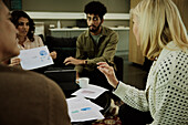 Gruppe von Geschäftsleuten bei der Analyse von Diagrammen während eines Meetings in der Lobby