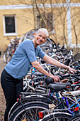 Portrait einer lächelnden reifen Frau beim Fahrradparken