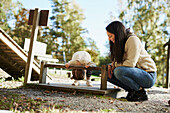 Mother looking at daughter playing at playground\n