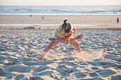 Blondes Mädchen spielt am Strand