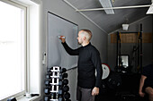 Mann schreibt auf Whiteboard im Fitnessstudio
