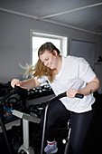 Blonde Frau trainiert im Fitnessstudio