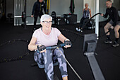 Smiling senior woman exercising in gym\n