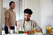 Glückliches schwules Paar beim Frühstück zu Hause