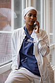 Young female doctor talking on phone at work\n