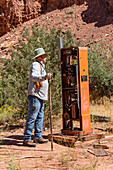 Ein Mann betrachtet eine verfallene Benzinpumpe auf dem Gelände der Big Buck Uranmine im Steen Canyon bei La Sal, Utah.