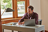 Man working at desk at home\n