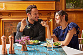 Smiling couple enjoying dinner at home\n