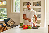 Man cutting vegetables in kitchen\n