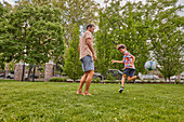 Vater und Sohn (8-9) beim Fußballspielen im Park
