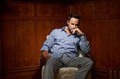 Portrait mittlerer Erwachsener Mann auf Stuhl sitzend