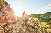 Mid adult woman meditating in mountains\n