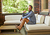 Mid adult man relaxing on sofa on patio\n