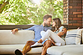 Mittleres erwachsenes Paar entspannt auf dem Sofa auf der Terrasse