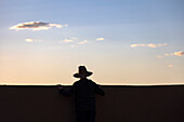 Silhouette eines Mannes mit Hut bei Sonnenuntergang