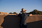 USA, New Mexico, Santa Fe, Rear view of man in hat looking at sky\n