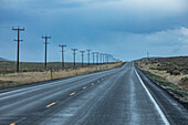 USA, Nevada, McDermitt, Electricity pylons along highway during stormy weather\n