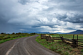 USA, Idaho, Bellevue, Dramatische Wolken über leerer Straße und Wiese