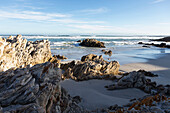 South Africa, Hermanus, Rocky coastline with Atlantic Ocean in Voelklip Beach on sunny day\n